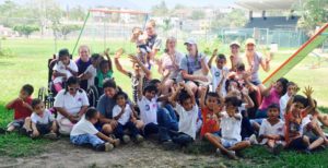 students playing with Mexican children in a playgroud