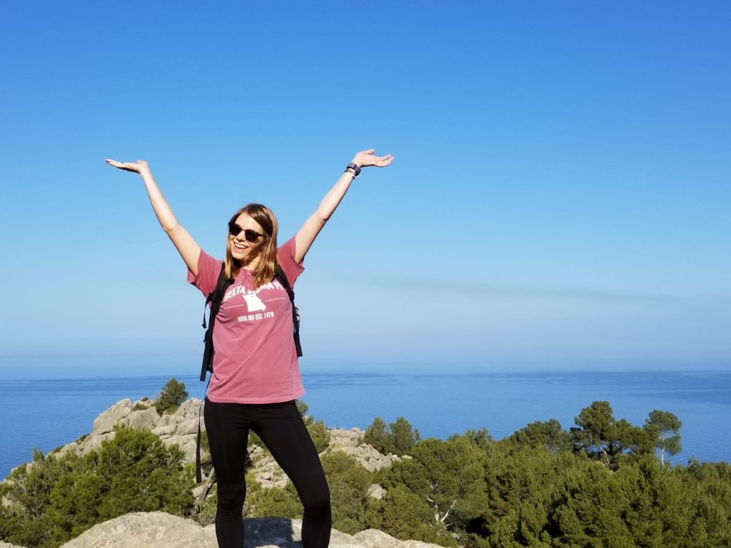 Student posing with sea in background